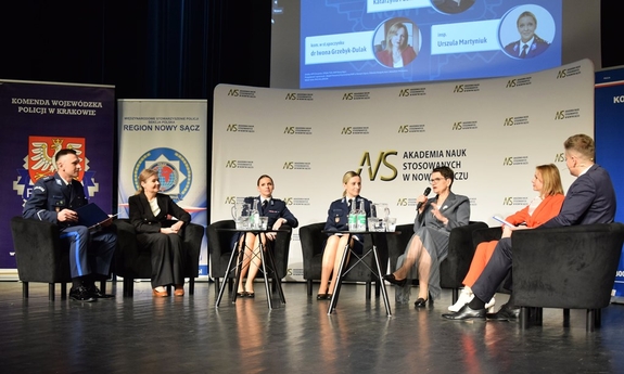 Uczestnicy konferencji siedzą na krzesłach.