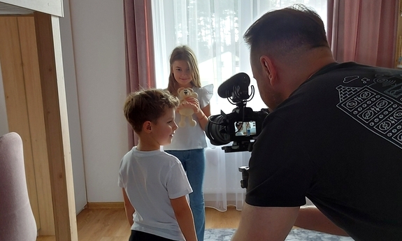 Mężczyzna filmuje dwójkę dzieci.
