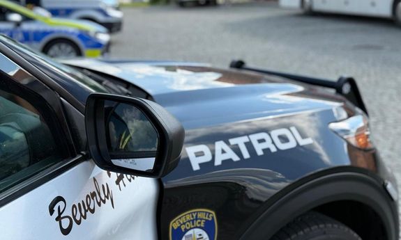 W tle widać radiowozy polskiej Policji, stary wóz strażacki oraz ambulans krwiodawstwa.