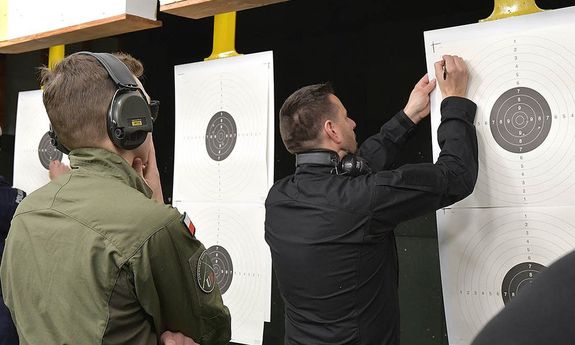 policjant sprawdza na tarczy strzelanie.