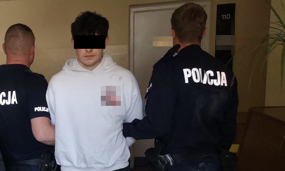 zatrzymany stoi z policjantami.