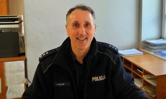 policjant siedzi przy biurku.