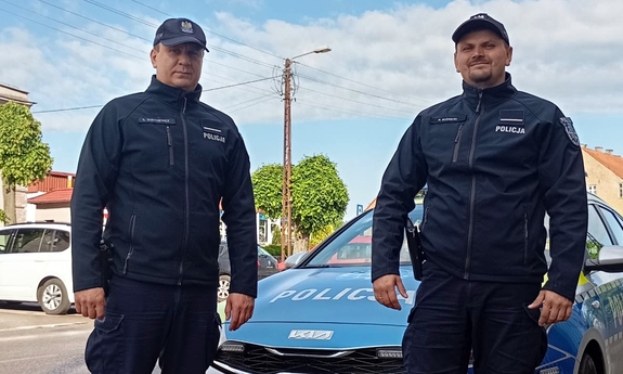 st. post. Łukasz Statkiewicz oraz st. post. Paweł Klepacki stoją przy radiowozie.