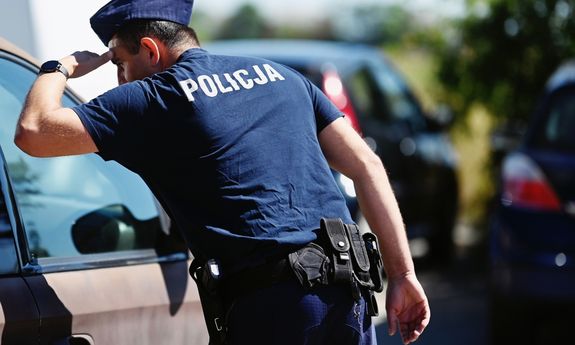 Policjant sprawdzający czy wewnątrz auta nie ma pozostawionych dzieci lub zwierząt.