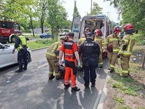 Służby ratunkowe pracują na miejscu wypadku z udziałem motocyklisty.