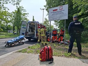Służby ratunkowe pracują na miejscu wypadku z udziałem motocyklisty.