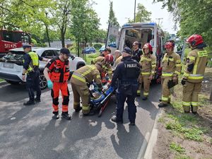Służby ratunkowe pracują na miejscu wypadku z udziałem motocyklisty.