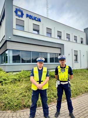 policjanci stoją przed budynkiem.
