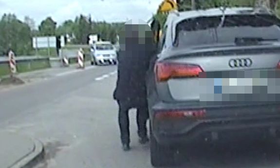 mężczyzna próbuje zatrzymać samochód, który się toczy.