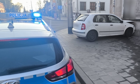 Miejsce zdarzenia, na którym widać białą skodę, która uderzyła w budynek i policyjny radiowóz.