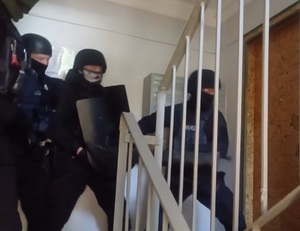 Policyjni kontrterroryści wchodzą do mieszkania.