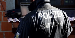 Niemiecki policjant przy laptopie - widok z tyłu.