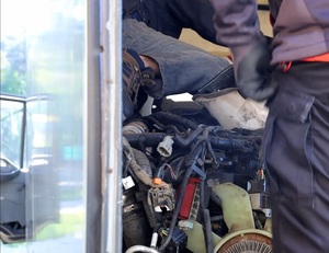 Widoczne nogi policjantów i części samochodowe.