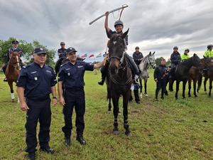 policjantka na koniu trzyma w ręku szablę uniesioną do góry