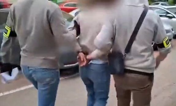 dwóch policjantów idzie z zatrzymaną.