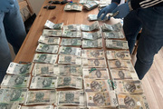 Zabezpieczone banknoty rozłożone na stole.