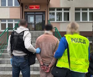 Policjanci z zatrzymanym za oszustwa.