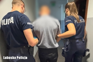 Dwoje policjantów prowadzi zatrzymanego.