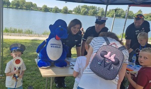 Policjanci w namiocie profilaktycznym z uczestnikami wydarzenia.