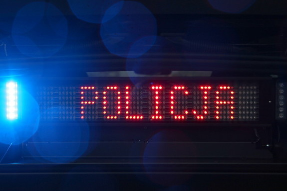 Napis Policja na belce na dachu radiowozu.