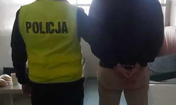 policjant stoi z zatrzymanym.