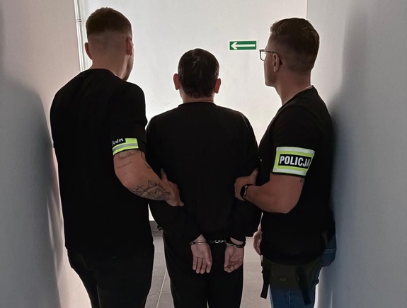 Dwaj policjanci z zatrzymanym mężczyzną.