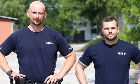 Dwóch policjantów stoi i pozuje do zdjęć.