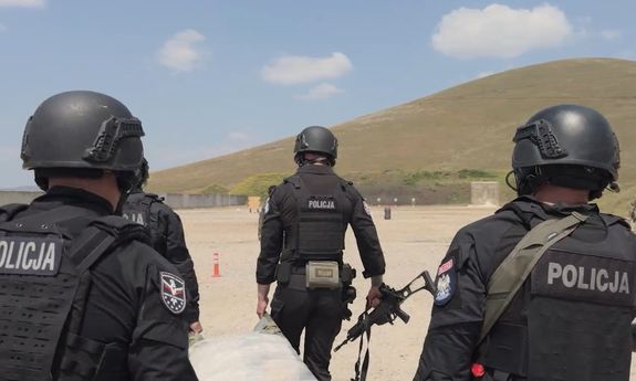 Trzech policjantów idzie przez pustynię .