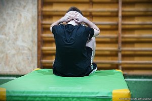 Na zdjęciu osoba na materacu, która wykonuje siad z leżenia na plecach mając ręce założone z tyłu głowy.