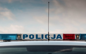 Napis Policja na belce na dachu radiowozu.