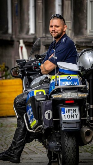 Policjant oparty o motocykl.