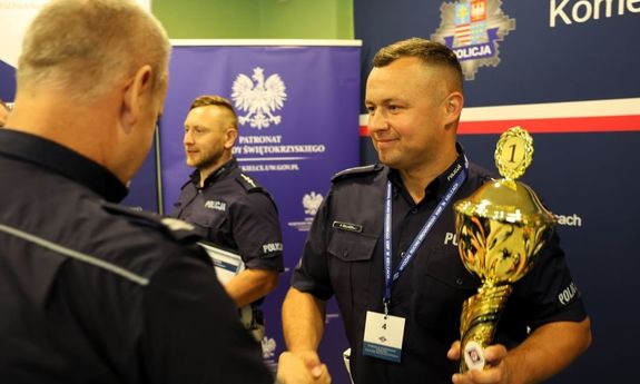 Na zdjęciu dwóch policjantów, gdzie jeden gratuluje drugiemu zwycięstwa