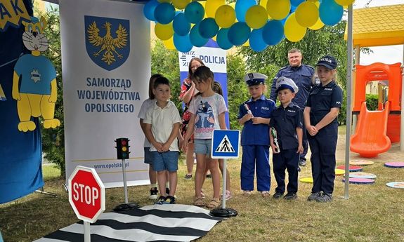 Grupa dzieci,  których część jest przebrana za policjantów.