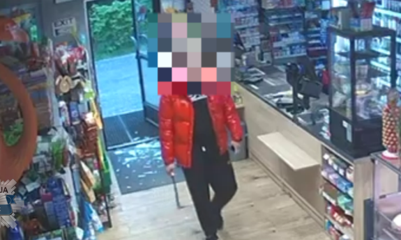 Stopklatka z nagrania monitoringu przedstawia mężczyznę, który z maczetą napadł na sklep.