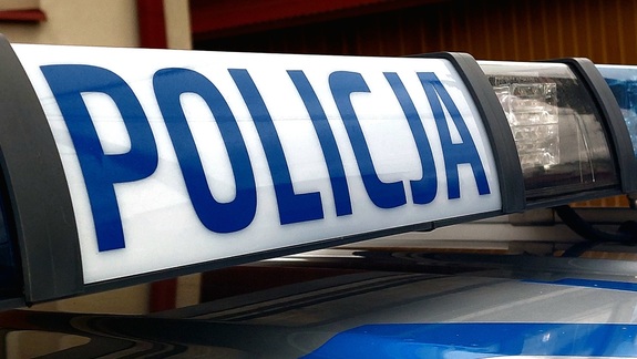 Napis Policja znajdujący się na belce na dachu radiowozu.