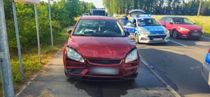 Auto zatrzymanego mężczyzny obok policyjnego radiowozu.