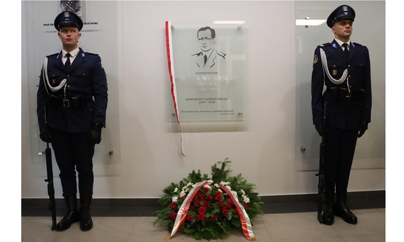Dwaj policjanci stoją przy odsłoniętej tablicy pamiątkowej śp. nadinsp. Marka Papały.