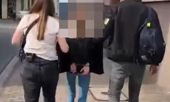 dwóch policjantów idzie z zatrzymaną.