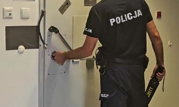 policjant zamyka drzwi do celi.