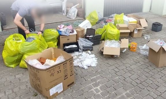 Policjant podczas zabezpieczenia podrobionych artykułów.