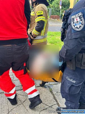 Policjanci strażacy i medycy przenoszą mężczyznę.