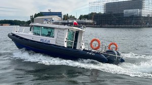 Policyjna łódź na wodzie - widok z boku.