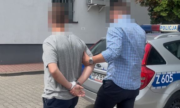 policjant idzie z zatrzymanym.