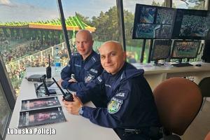 dwóch policjantów siedzi przy biurku.