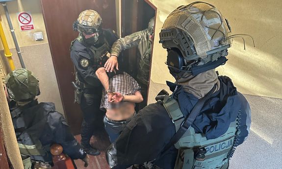 Policjanci prowadzą zatrzymanego.