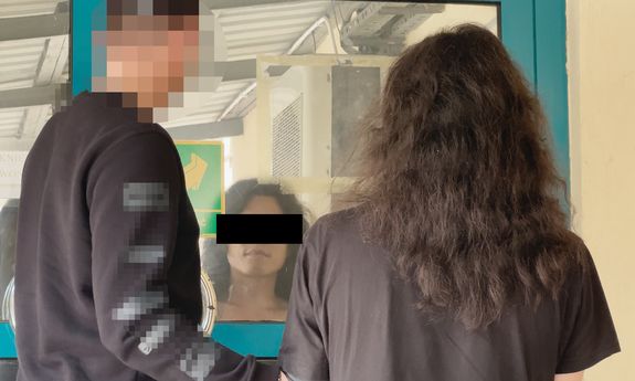 Nieumundurowany policjant prowadzi zatrzymanego.