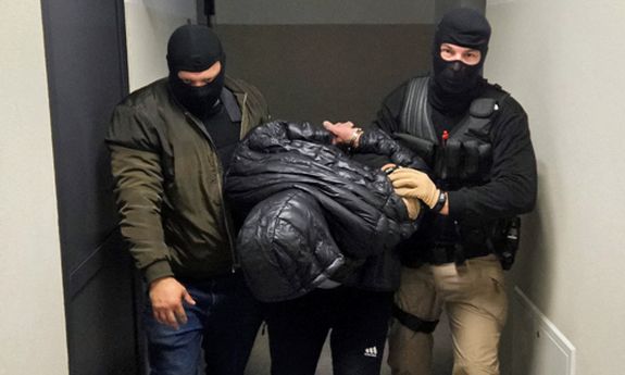 Dwaj policjanci prowadzą zatrzymanego.