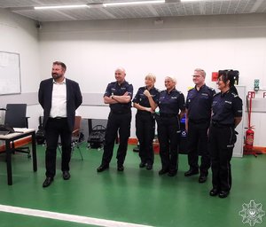 nadinsp. dr Rafał Kochańczyk - Zastępca Komendanta Głównego Policji w towarzystwie innych policjantów w pomieszczeniu.