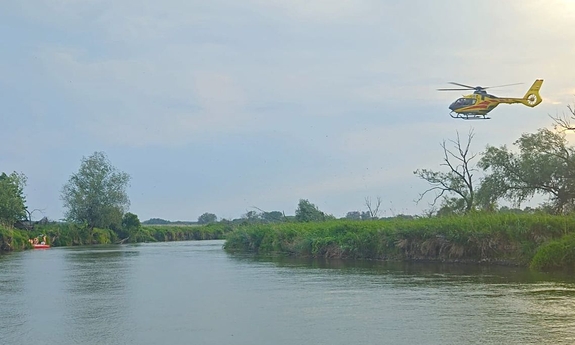 śmigłowiec LPR nad rzeką Wieprz na łodzi strażacy.