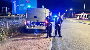 Dwaj policjanci przy radiowozie.